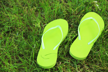 Bright flip-flops on green grass