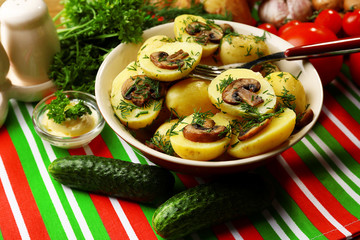 Young boiled potatoes with mushrooms on table, close up
