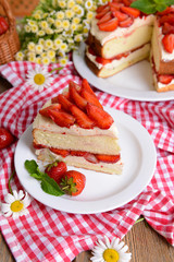 Delicious biscuit cake with strawberries on table close-up