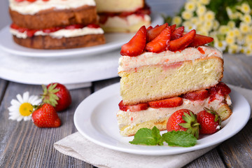 Delicious biscuit cake with strawberries on table close-up