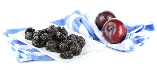 Fresh and dried plums  on napkin, isolated on white