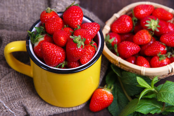Ripe sweet strawberries in wicker basket and mint leaves