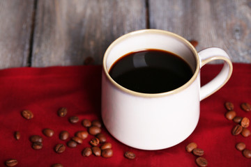 Cup with hot coffee and roasted coffee grains