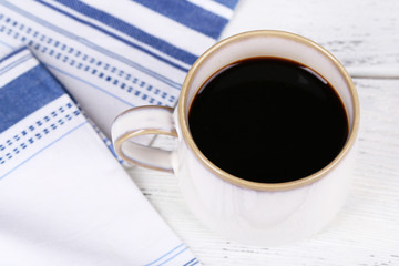 Cup with hot coffee on color  wooden background
