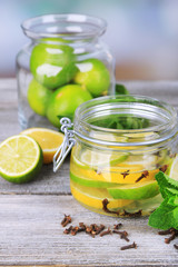 Pickled limes and cloves in glass jar,