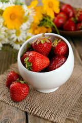 Ripe sweet strawberries in bowl on table close-up
