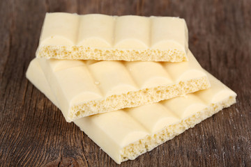 White chocolate bar on color wooden background