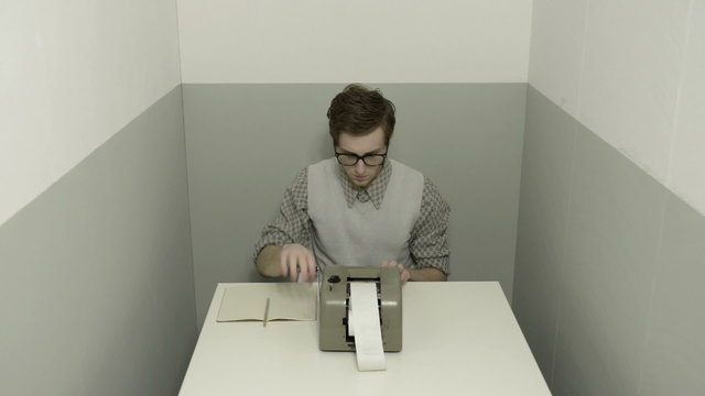 Young efficient accountant working at desk with vintage calculat