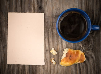 Croissant with coffee and a note paper