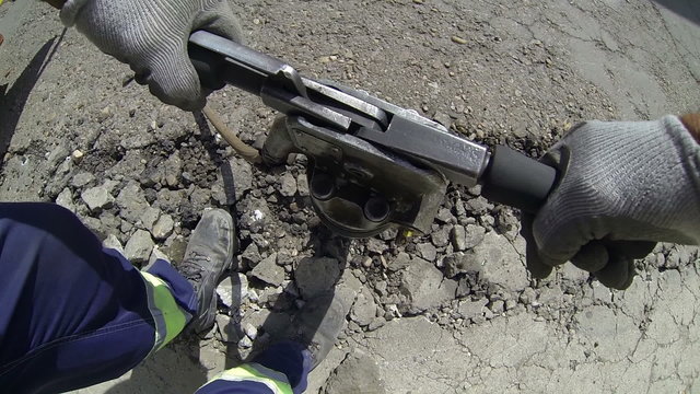 Workmen Using Pneumatic Drill to Dig Up a Road - POV