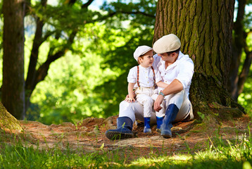 Naklejka na ściany i meble father and son sitting under an old tree