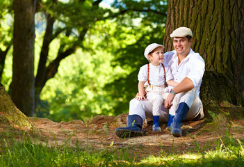 Fototapeta premium father and son sitting under an old tree