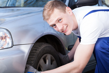 Auto mechanic checks a car tire