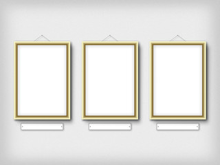 Gallery interior with three empty frames on wall.