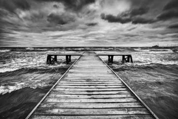 Foto op Canvas Old wooden jetty during storm on the sea. Dramatic sky © Photocreo Bednarek