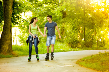 Lovers in nature on rollerblades - obrazy, fototapety, plakaty