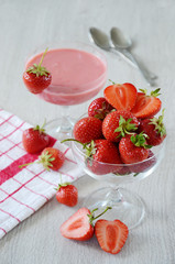 Strawberries in a bowl with a towel and two spoons