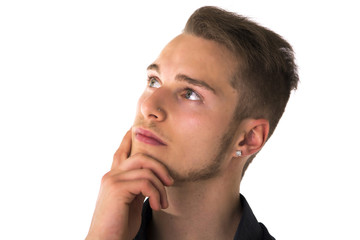 Obraz premium Attractive young man thinking, looking up with hand on his chin