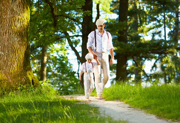 Fototapeta premium father and son walking the forest sunlit path