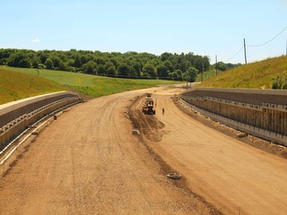 Fototapeta na wymiar Building of new highway, scraper modify surface or gravel. 