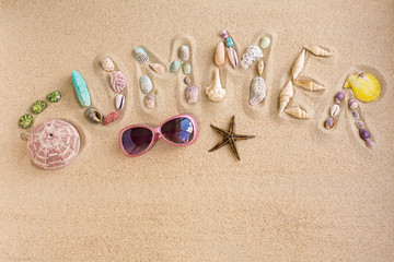 Fototapeta na wymiar Word summer made from sea shells, with sunglasses and star fish,