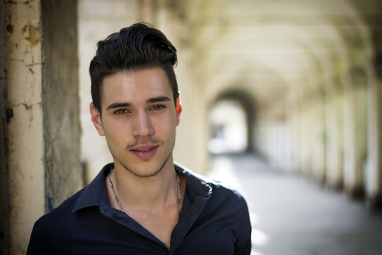 Handsome Young Man Standing Outdoors Under Old Colonnade