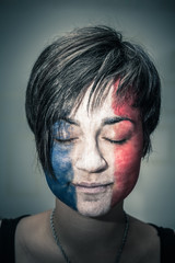 Woman with flag of France on face and closed eyes