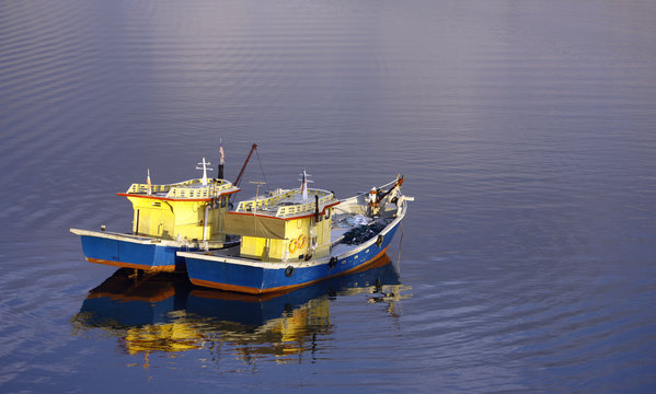 Two fishing boats floating on rippling water