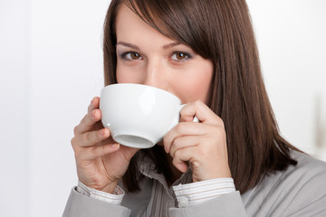 Business woman drinking tea from white cup, isolated on white