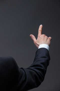 Close up of pointing hand, isolated on grey background
