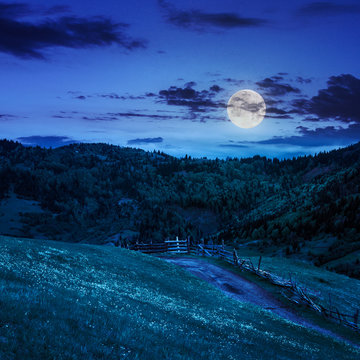 fence on hillside meadow in mountain at night
