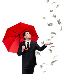 Palming up man with opened umbrella looking at falling money