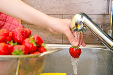 girl washes strawberries