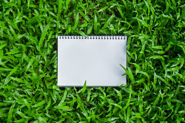 a note pad on greenery grass