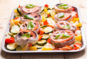 Raw mushrooms with cooked vegetables and leafs of basil