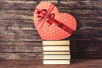 Gift and books on wooden table.