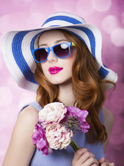 Redhead girl with flowers on pink background.