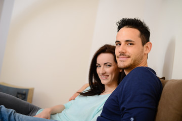 happy lovely  young couple at home in sofa watching tv together