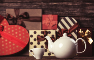 Teapot and gifts on background.