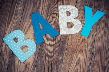 letters of word baby on wooden background