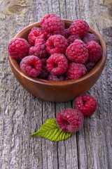 Healthy organic raspberries in a bowl on the old rustic table