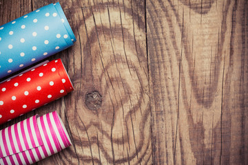 Fototapeta premium Rolls of colored wrapping paper on wooden background