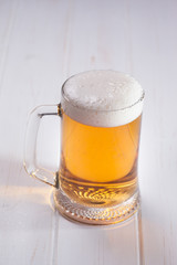 Mug of beer on wooden background