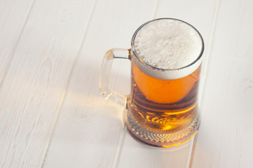 Mug of beer on wooden background