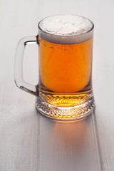 Mug of beer on wooden background