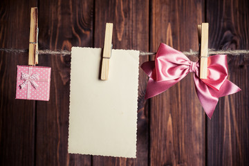 old paper sheet with bow and small gift box hanging on clothesli