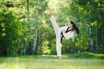 Karate girl makes high kick on forest outdoor location © Fotokvadrat