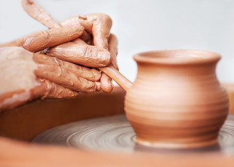 Hands working on pottery wheel