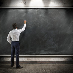 businessman presents a written report on a blackboard