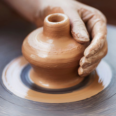 Potter hands making in clay on pottery wheel. Potter makes on th